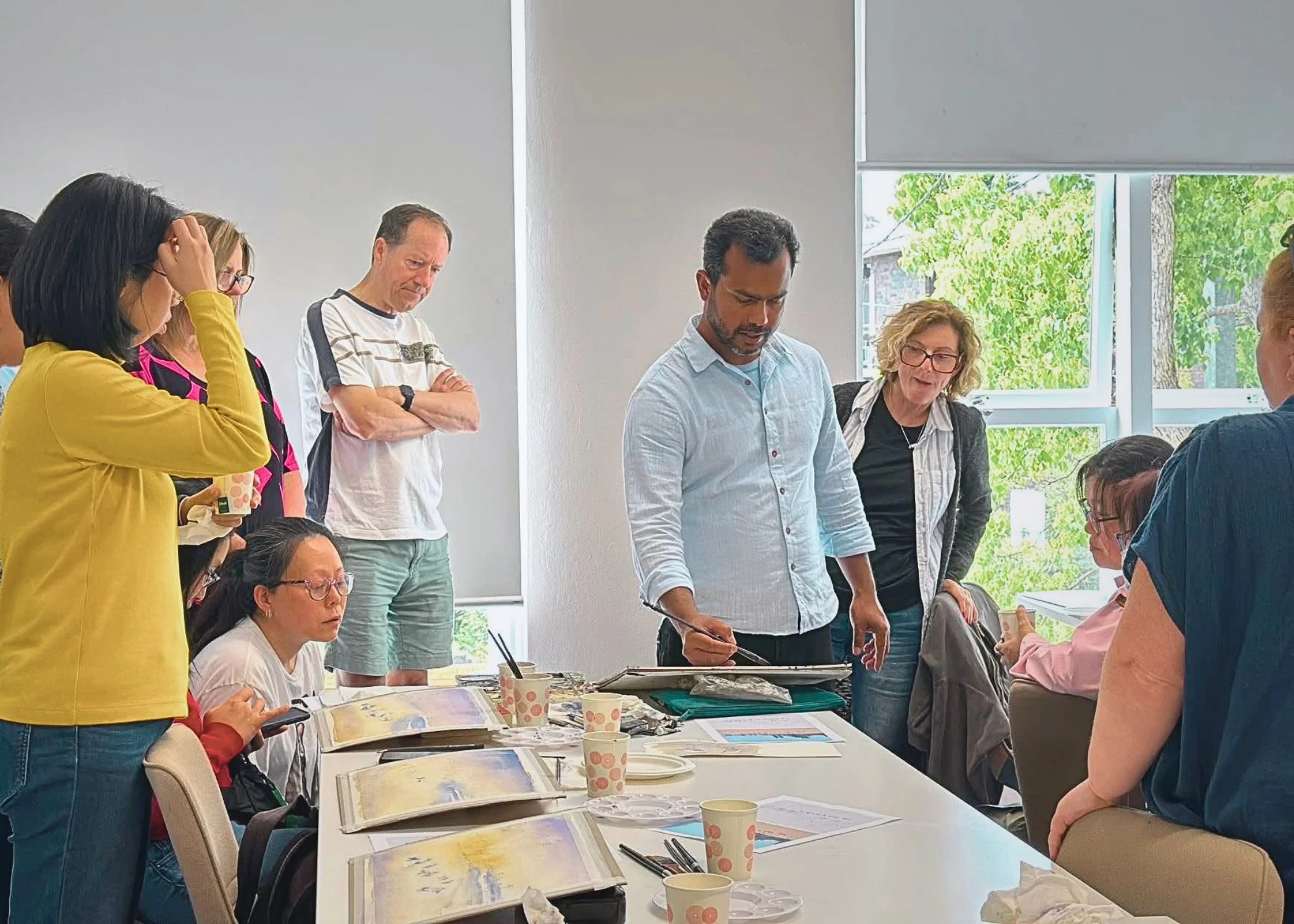Participants and artist around the table at a Sienna Arts watercolour session
